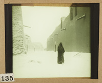 A woman in an Iraqi abaya along a street of al-Zubayr