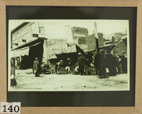 Villagers in the market place; in the foreground a traditional house in Basra