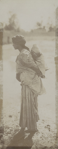 Local woman carrying sleeping child on back